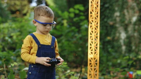 Portrait of little boy with remote control crane beam in an industrial warehouse Stock Footage 229730530