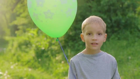 Portrait of a little boy smiling to the camera with a balloon Stock Footage 85001470