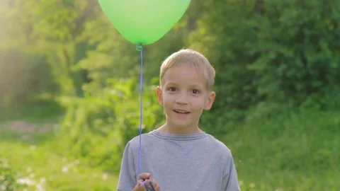Portrait of a little boy smiling to the camera with a balloon Stock Footage 85001490