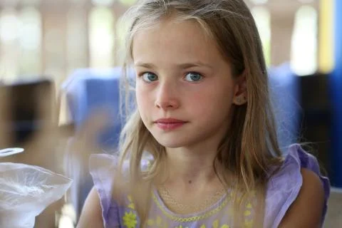 Portrait of a little girl with long hair and blue eyes of a blonde who is res Stock Photos