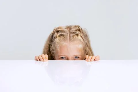 Portrait of little preschool girl, child playing hide-and-seek game isolated Stock Photos