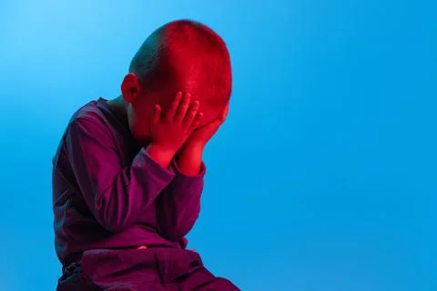 Portrait of little sad boy, kid, preschool age child isolated on blue studio Stock Photos