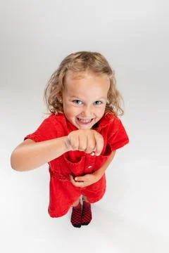 Portrait of little smiling Caucasian girl in red romper posing isolated over Stock Photos