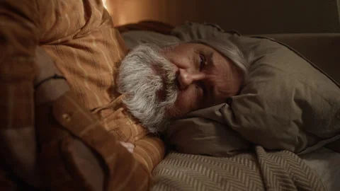 Portrait of Lonely Senior Man Lying in Bed Suffering from Depression Vídeo Stock 337574070
