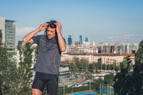 Portrait of a long haired athlete posing in a city park Stock Photos