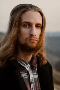 Portrait of long haired bearded guy in the susnet Stock Photos