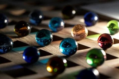 A portrait of a lot of different marbles in different colors, lying on a wood Stock Photos