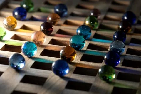 A portrait of a lot of different marbles in different colors, lying on a wood Stock Photos