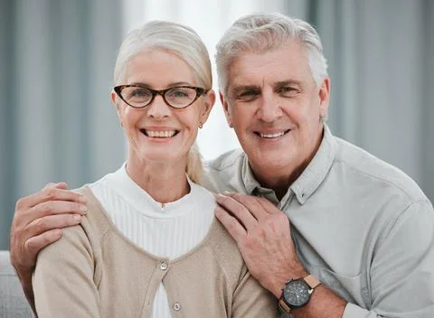 Portrait, love or commitment with a senior couple hugging in the living room of Stock Photos