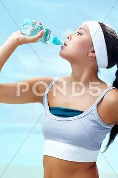 Portrait of lovely girl holding bottle of water in hand and drinking Stock Photos