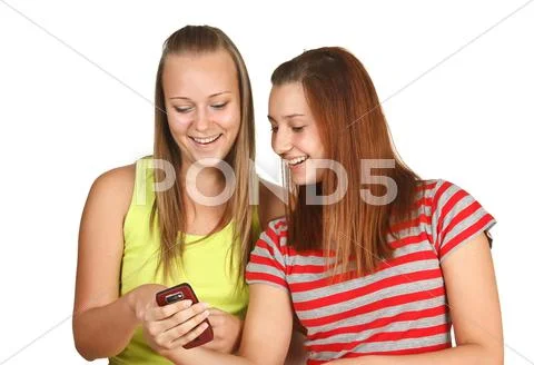 Portrait of lovely young women using mobile phone together Stock Photos