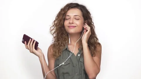 Portrait of magnetic beautiful girl listening to music using mobile phone and Stock Footage