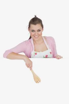 Portrait of maid pointing with wooden spoon Stock Photos