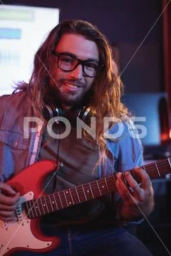 Portrait Of Male Audio Engineer Playing Electric Guitar