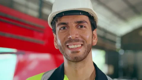 Portrait of male engineer looking to camera and smiling at factory. Video stock 229619624