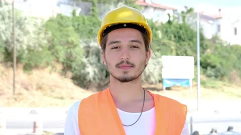 Portrait of male engineer or worker with yellow helmet looking at camera Stock Footage 136883555