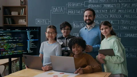 Portrait of Male Programming Teacher with Diverse Young Students by Blackboard Stock Footage 306979917