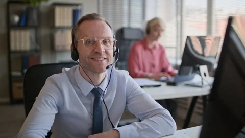 Portrait of Male Support Agent in Headset Working on Computer in Call Center Stock Footage 335758447