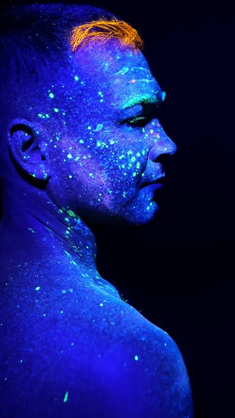 Portrait of a man against a dark background, painted with fluorescent paints. Stock Footage 314338580