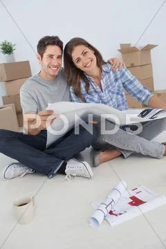 Portrait of man and his wife holding house plans Stock Photos