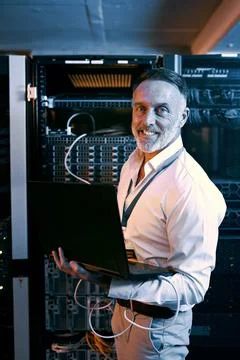 Portrait, man and programmer with laptop in server room for research, coding and Stock-Fotos