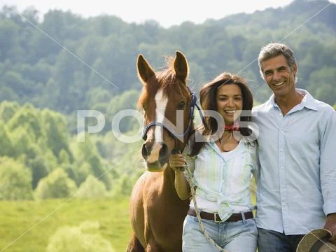 Portrait of a man and a woman standing with a horse Stock Photos