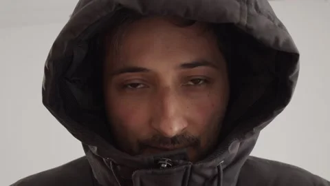 Portrait A man of Arab appearance in a black jacket with a hood pulled down over Video stock 240855953