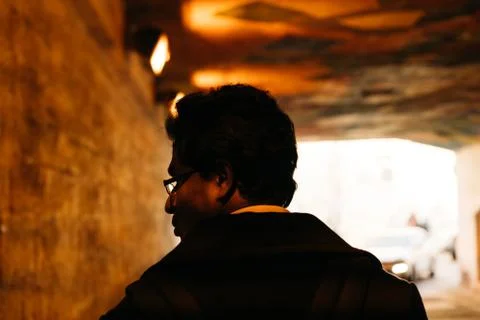 Portrait of a man in the backlight looking back in a tunnel Stock Photos