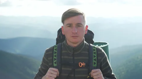 Portrait of a man with a backpack, hiking, looking into the frame Stock Footage 217395435