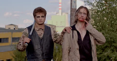 Portrait man bat on his shoulder keeps his hand on the shoulder of a zombie. Video stock 218438587