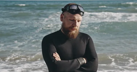 Portrait of man with beard on background of sea waves. Adult serious man swimmer Stock Footage 143893636