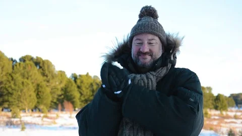 Portrait of a man with a beard in a knitted hat and scarf. Winter landscape in Video stock 83117072