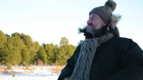 Portrait of a man with a beard in a knitted hat and scarf. Winter landscape in Stock Footage 83122212