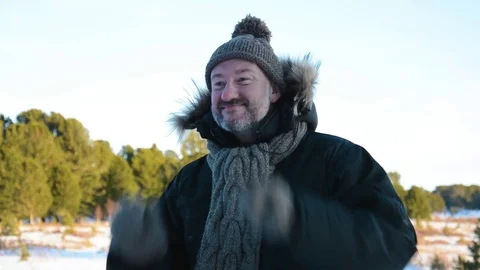 Portrait of a man with a beard in a knitted hat and scarf. Winter landscape in Stock Footage 83124640