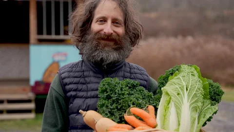Portrait of a man with a big beard holding a basket of fresh produce Stock Footage 146803879