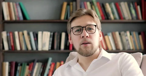 Portrait of man blogger talking on camera and waving hand greeting subscribers. Vídeo Stock 132099965