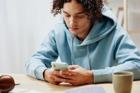 Portrait of a man in a blue jacket in front of a computer with phone interior Stock Photos