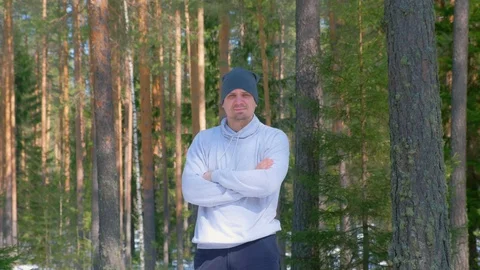 Portrait of man in cap in pine forest standing and looking at camera. Stock Footage 129600657