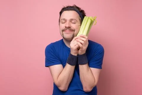 Portrait of a man with celery on white background Stock Photos