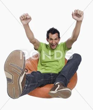 Portrait of a man cheering on a bean bag Stock Photos
