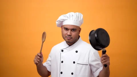 Portrait of man chef holds the kitchen utensils and the turner with a serious. Video stock 172283952
