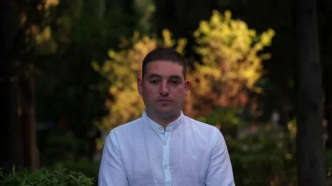 Portrait of a man close-up on a background of trees in the park. Stock Footage 139592894