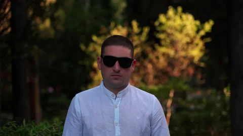 Portrait of a man close-up on a background of trees in the park. Stock Footage 139592921