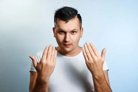 Portrait of a man close-up on a light background, shows a gesture with hands  Stock Photos