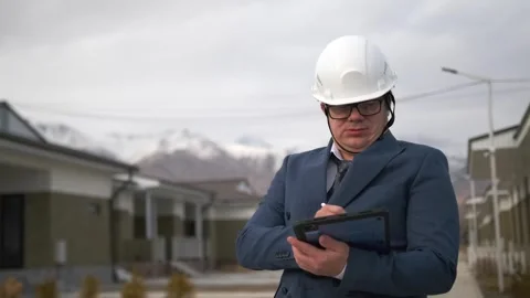 Portrait of man construction worker in suit and white helmet on building site Stock Footage 268383245