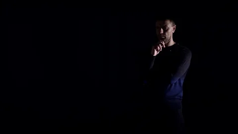 Portrait of a man in a dark studio. Technologies. Video stock 77677193