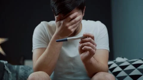 A portrait of a man in deep despair clutching a pregnancy test. The image Stock Footage 329280422