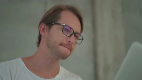 Portrait of a man developer wearing eyeglasses working with laptop at coffee Stock Footage 143583846