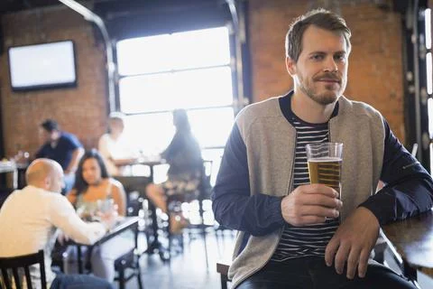 Portrait of man drinking beer in pub Stock Photos