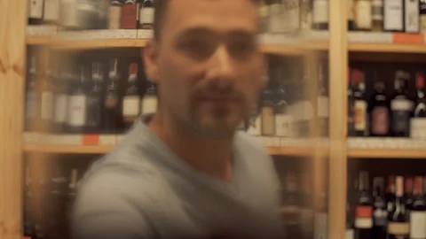 Portrait of man drinking red wine. Man puts his glass very close to camera and Video stock 99386499